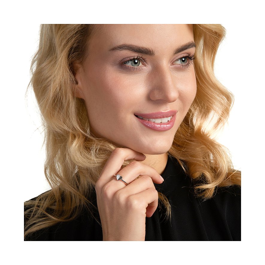 Nahaufnahme einer lächelnden Frau, die einen JETTE Ring aus Silber mit herzförmigem Zirkonia trägt.