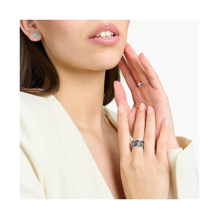 Model trägt einen Thomas Sabo Silberring mit Zirkonia-Farbsteinen und ein Paar Ohrstecker.