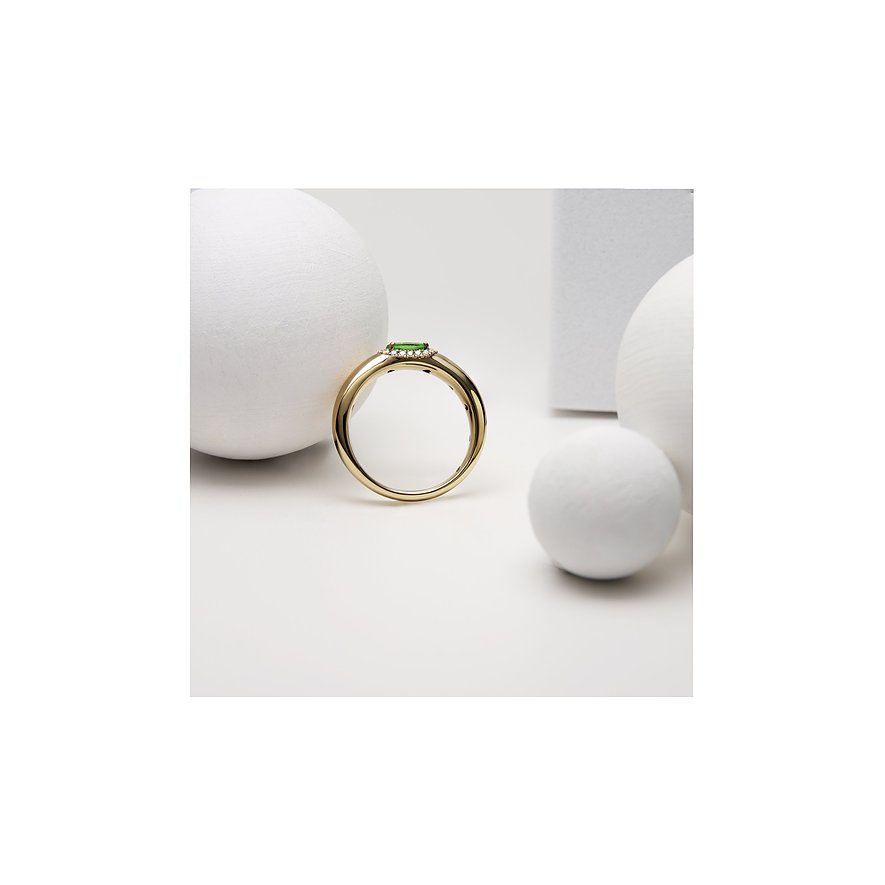 Ein Ring aus 585 Gelbgold von CHRIST mit einem grünen Tsavorit-Farbstein in der Mitte, umgeben von kleinen Steinen.