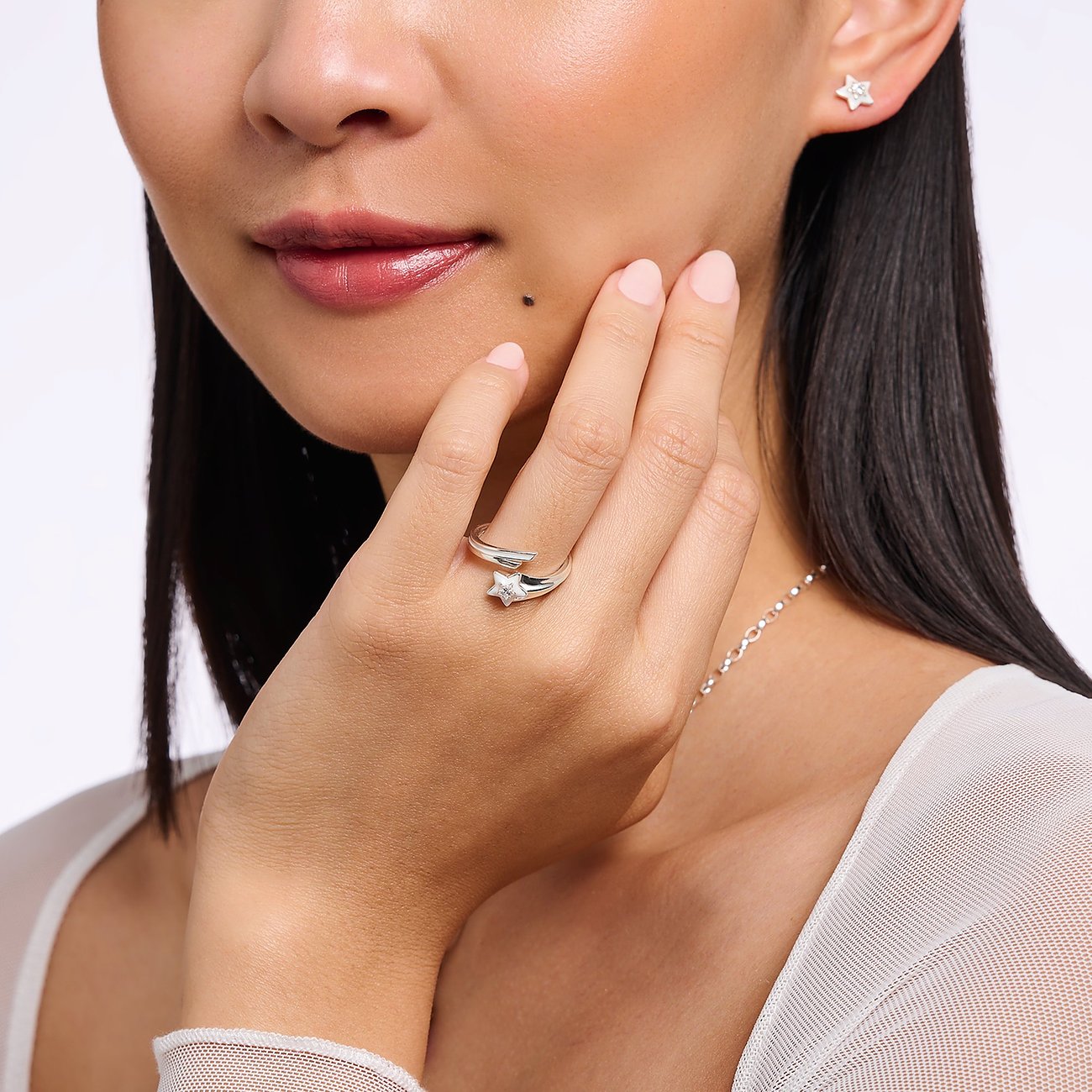 Ein Thomas Sabo Ring aus 925er Silber mit Zirkonia in Sternform an der Hand eines Models getragen.