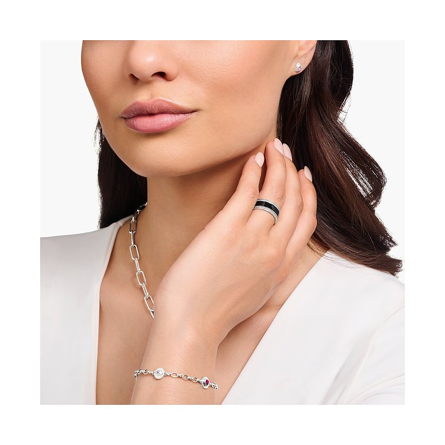 Close-up einer Frau, die am Ringfinger einen breiten Thomas Sabo Silberring mit schwarzem Emaille und Zirkonia trägt.