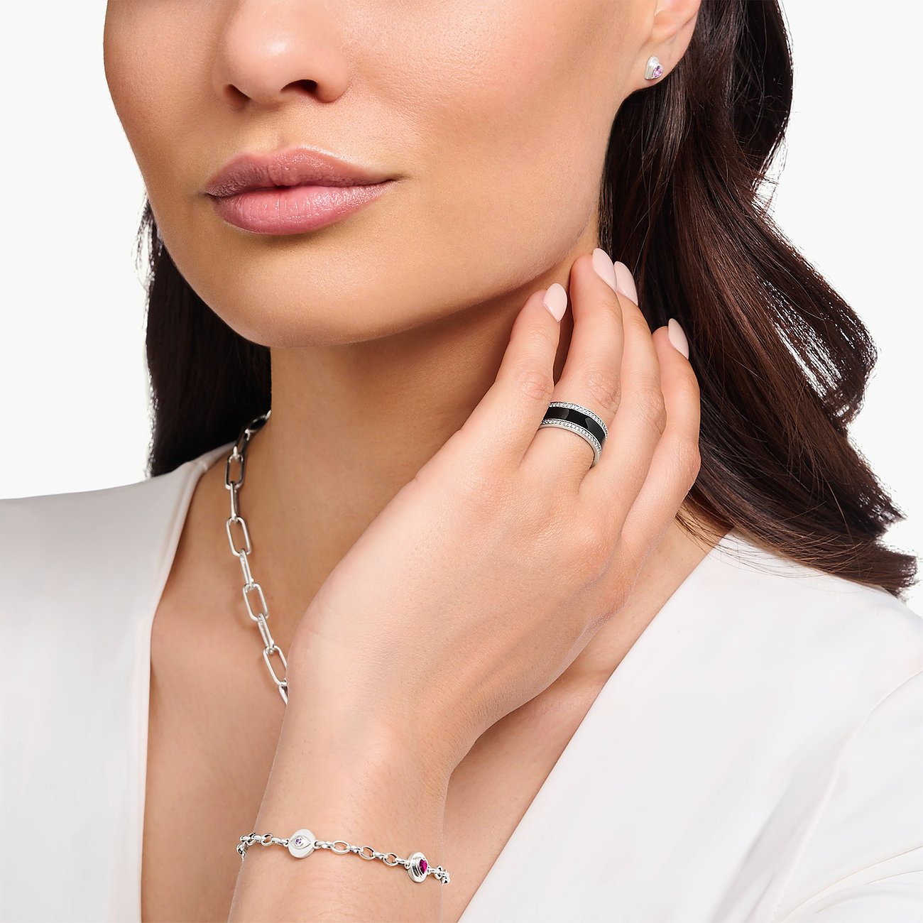 Close-up einer Frau, die am Ringfinger einen breiten Thomas Sabo Silberring mit schwarzem Emaille und Zirkonia trägt.