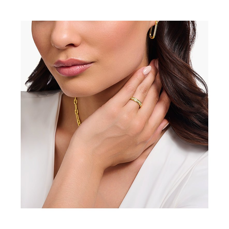 Eine Frau trägt einen goldenen Thomas Sabo Silberring mit Zirkonia, der auf dem Finger zu sehen ist.