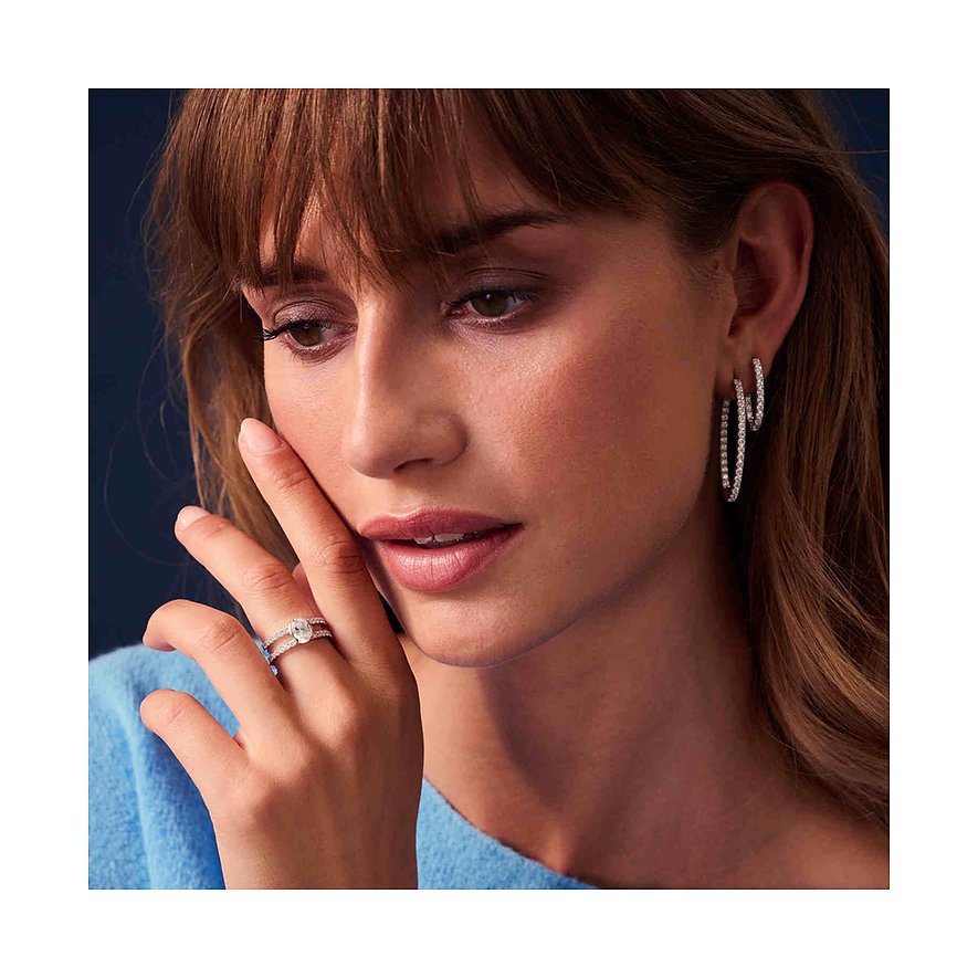 Eine Frau mit Sif Jakobs Jewellery Ohrschmuck aus Silber, der mit vielen kleinen Schmucksteinen besetzt ist.