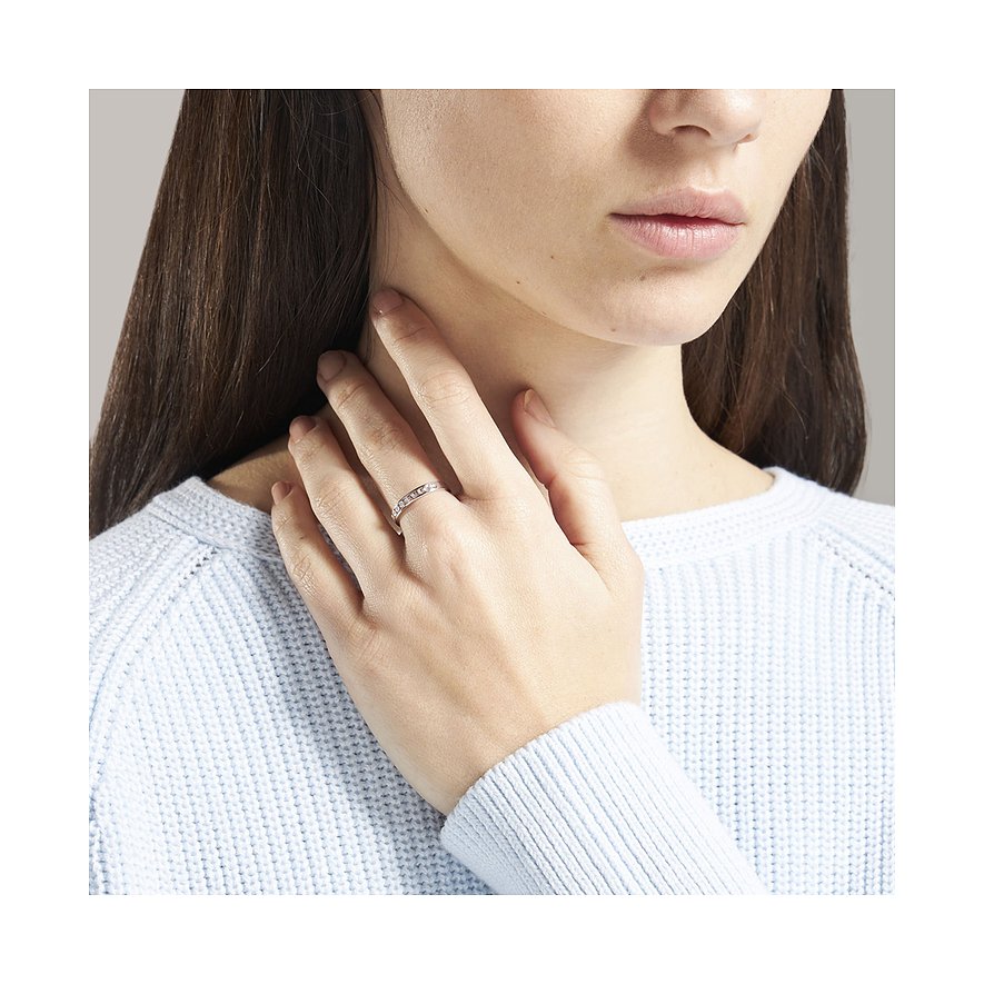 Nahaufnahme eines CHRIST 585 Weißgold-Rings mit Diamanten am Finger einer Frau die einen hellblauen Pullover trägt.