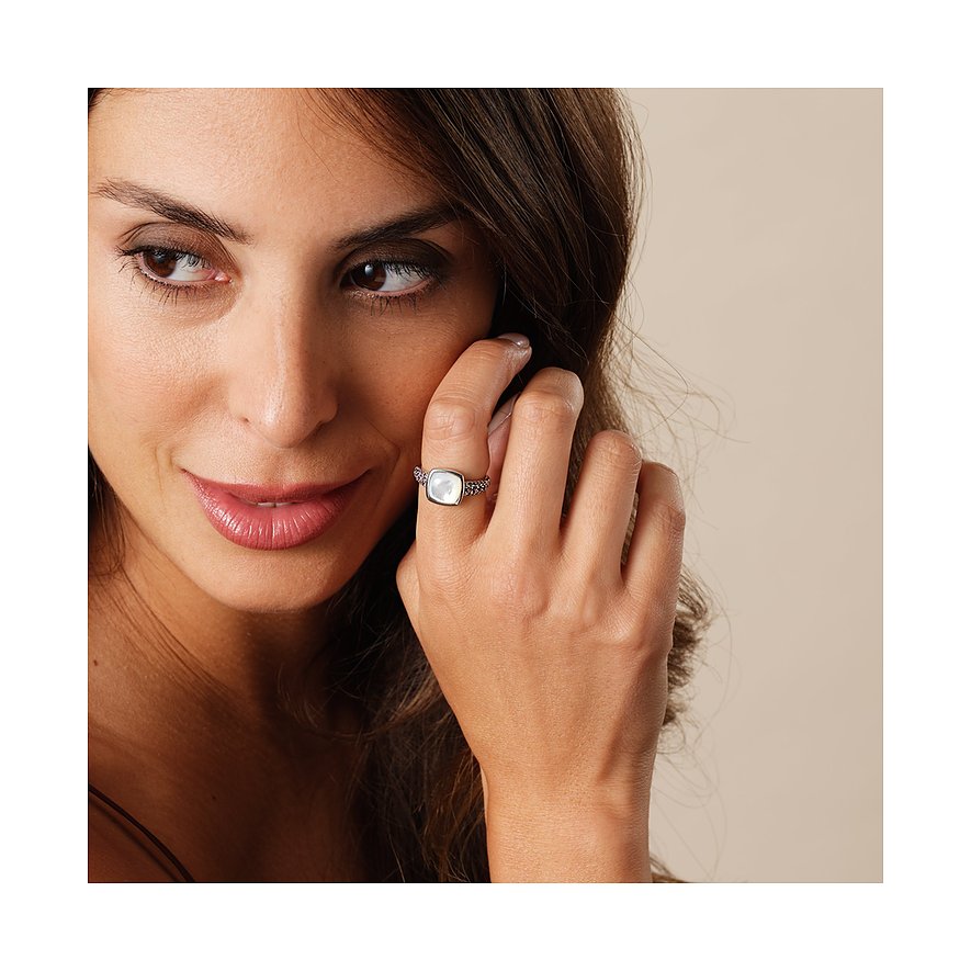 Eine Frau trägt einen CHRIST Ring aus recyceltem 925er Silber mit einer quadratischen Perle, die leicht schimmert.