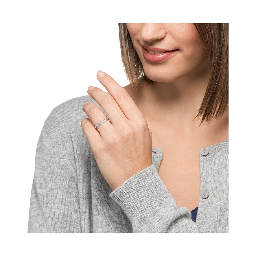 Eine Frau trägt einen schlichten CHRIST Ring aus Weißgold an ihrem Ringfinger, gesehen aus leicht schräger Vorderansicht.