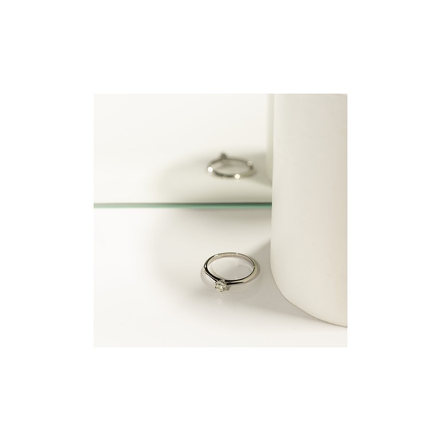 CHRIST Platin 950 Ring mit Diamant auf einer reflektierenden Oberfläche, angeschnitten von einem weißen Objekt.