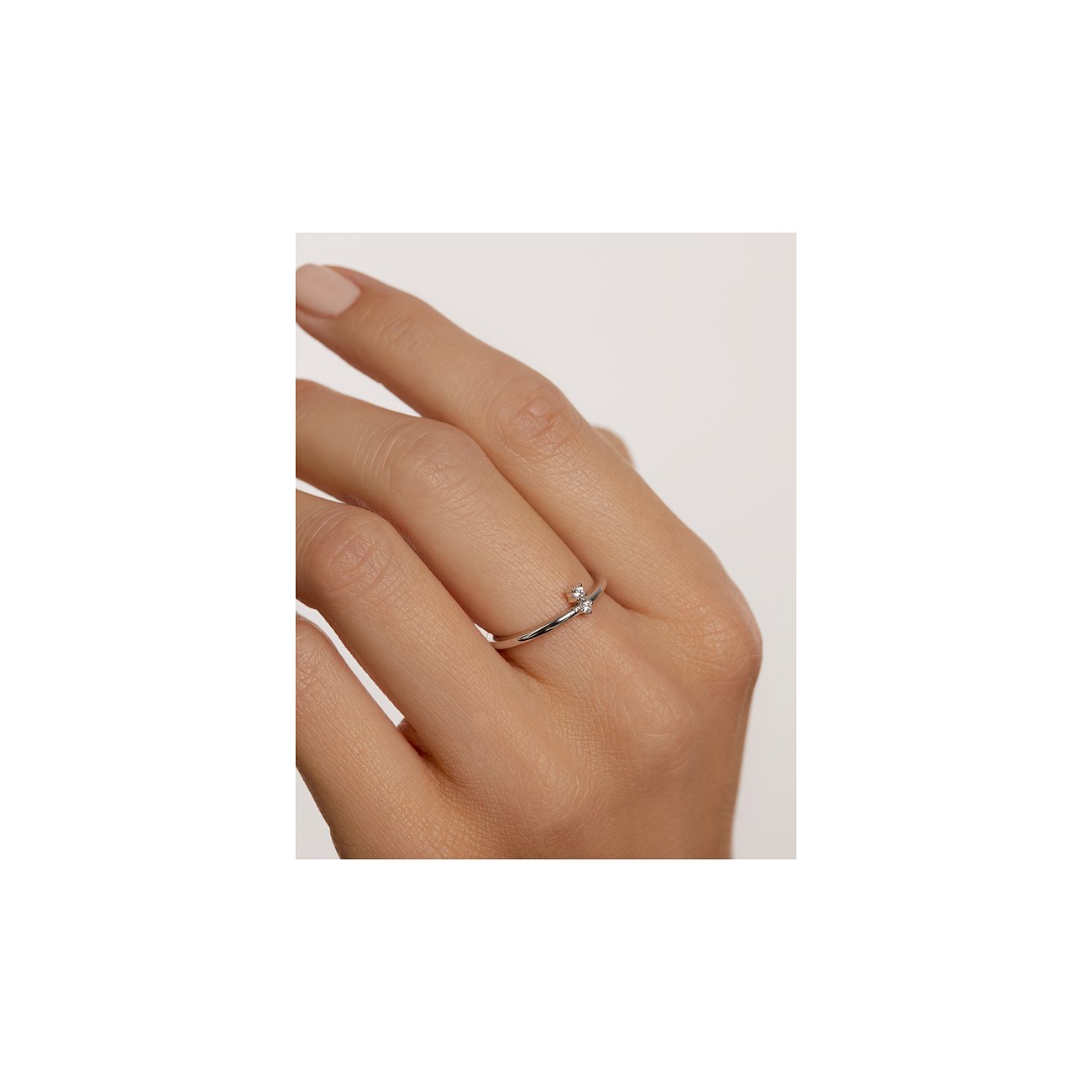Ein PdPaola Silberring mit zwei kleinen, klaren Zirkonia-Steinen, der am Finger getragen wird.