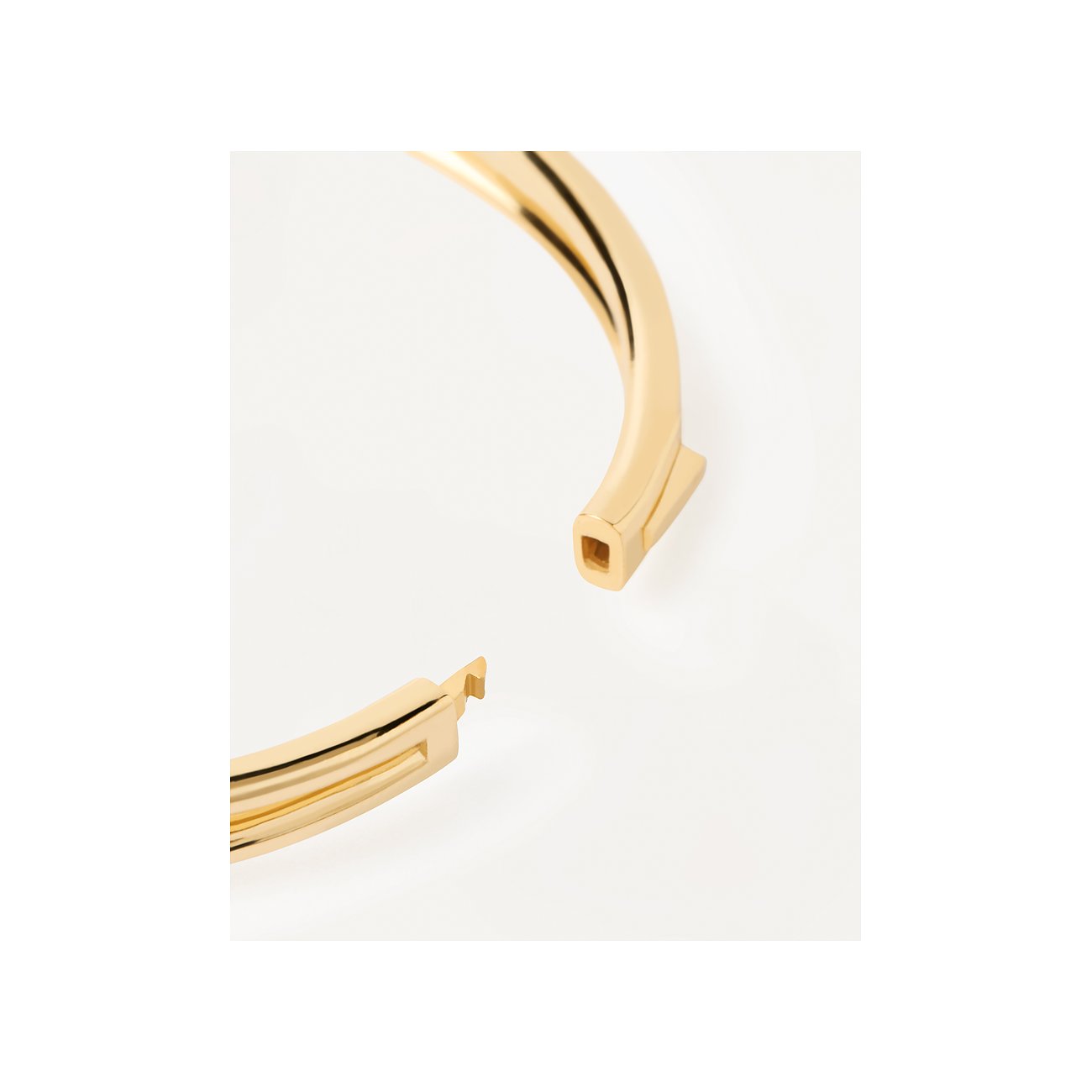 Närbild av ett PdPaola guldpläterat silverarmband, som visar det öppna snäpplåset.