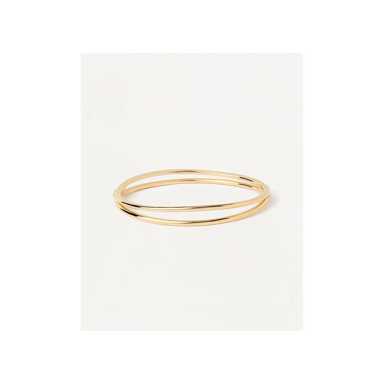 PdPaola armring i 925 sterlingsilver, trefaldigt guldfärgad och polerad, snett uppifrån mot vit bakgrund.