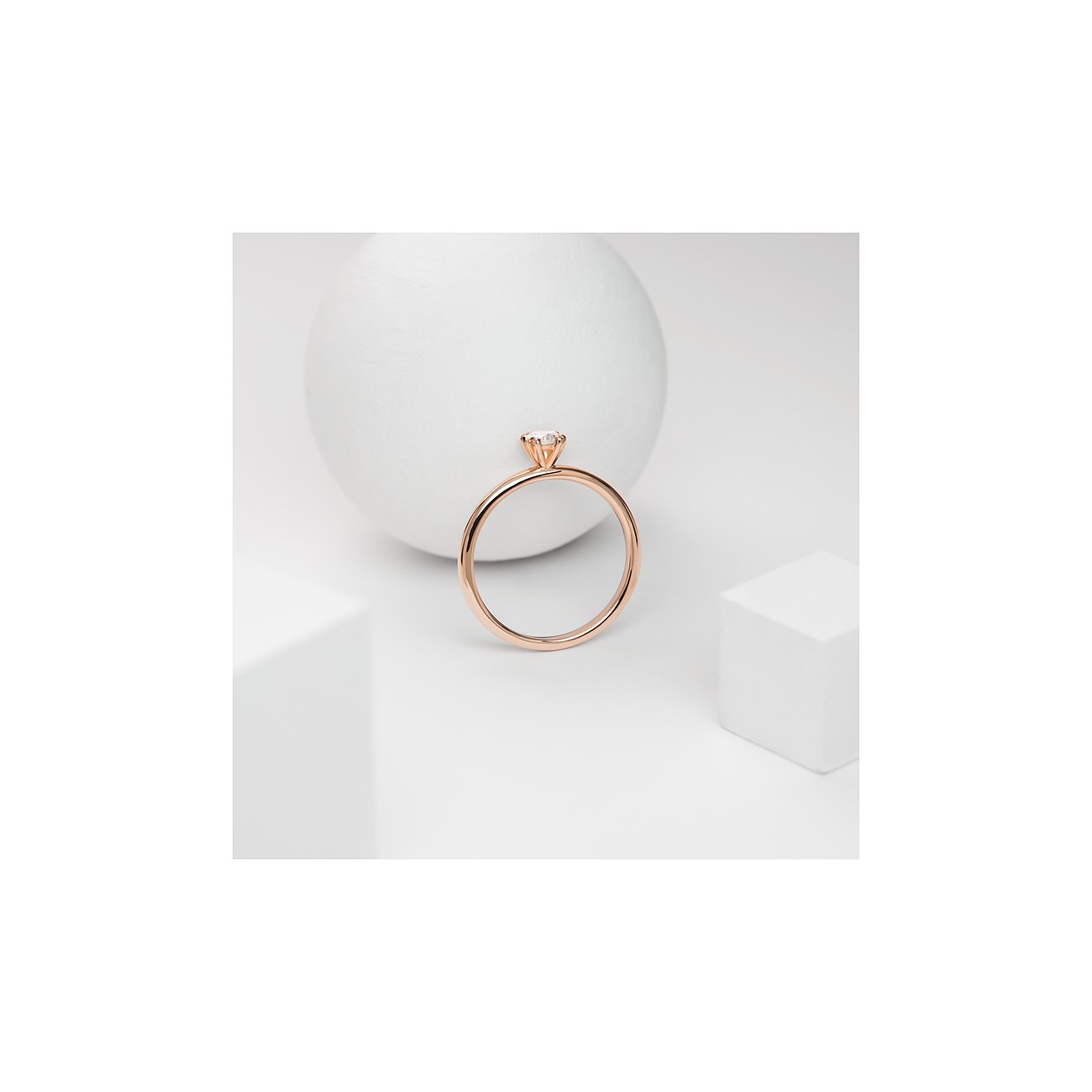 CHRIST Ring aus 585 Roségold mit einem einzelnen strahlenden Diamanten, schräg von oben auf Weiß fotografiert.