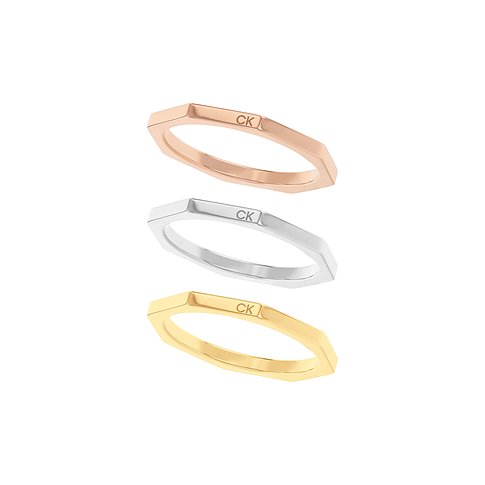 Drei gestapelte Calvin Klein Ringe aus Edelstahl in Roségold, Silber und Gelbgold, mit CK Logo auf der Oberseite.