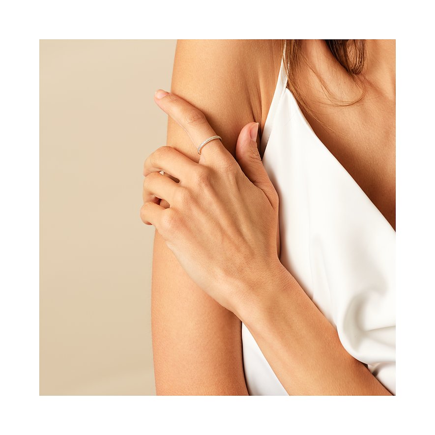 Am Ringfinger einer Person mit weißem Oberteil ist ein zarter CHRIST 585er Gelbgold Ring mit Diamanten zu sehen.