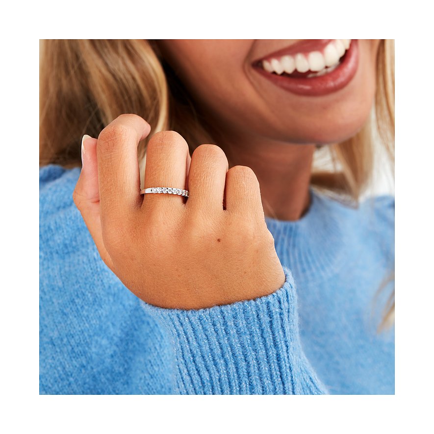 Nahaufnahme eines CHRIST 585er Weißgold-Rings mit Diamanten, getragen an einer Hand mit blauem Pullover.