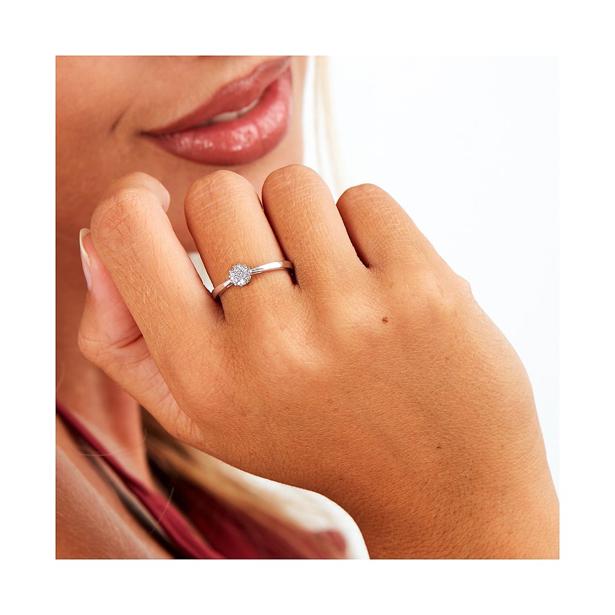 Nahaufnahme eines Rings aus 585er Weißgold mit funkelnden Diamanten an einer Hand, die das Gesicht berührt.