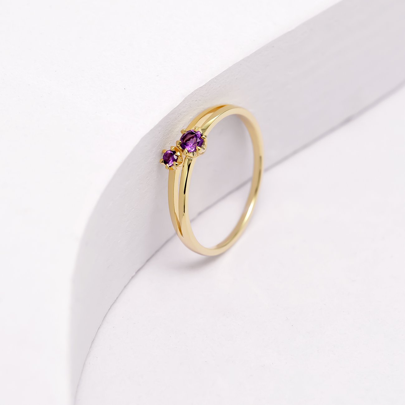 Eleganter Ring aus 375er Gelbgold mit zwei leuchtenden Amethysten in einem modernen Design.