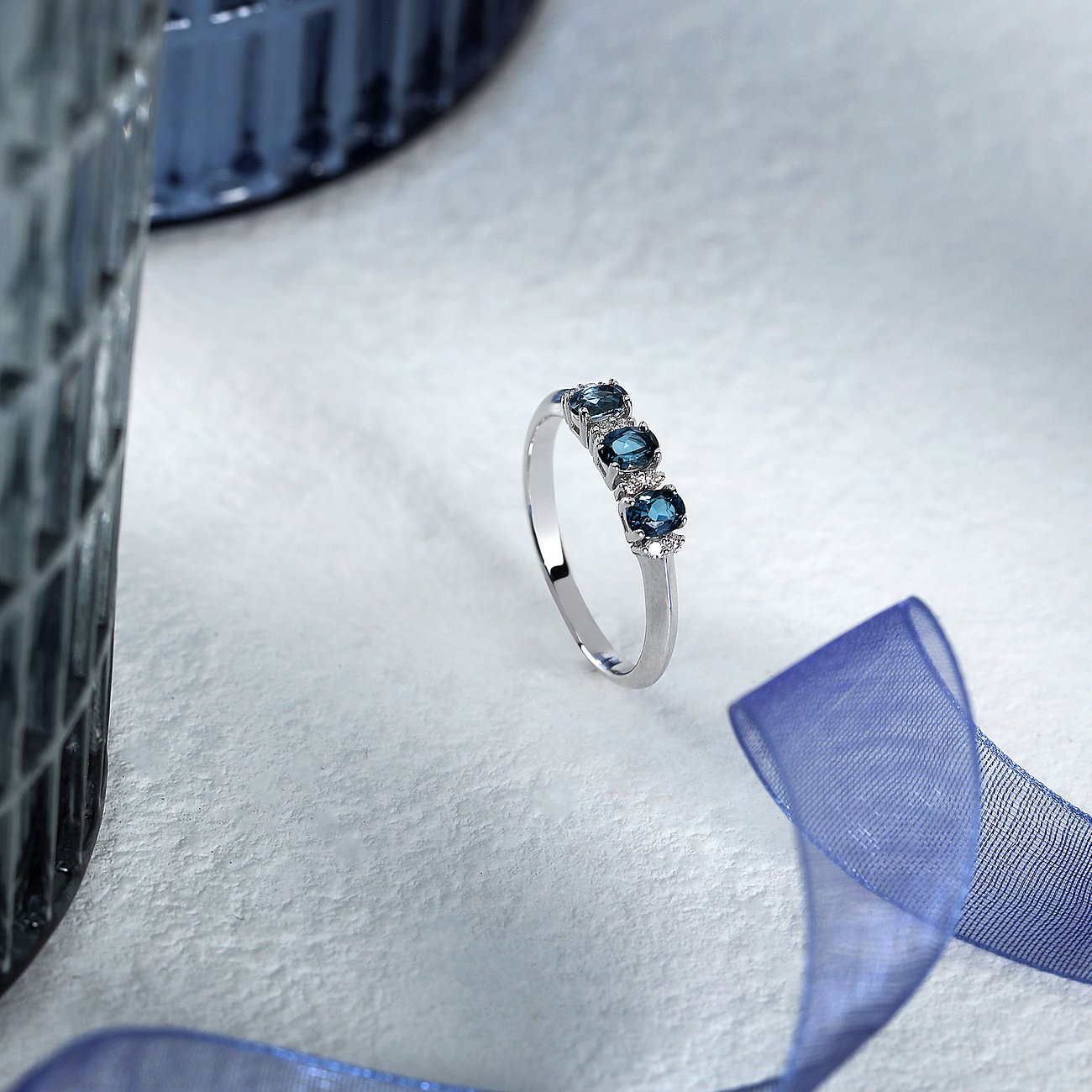 CHRIST Ring aus 585 Weißgold mit drei blauen Topasen und kleinen weißen Steinen.