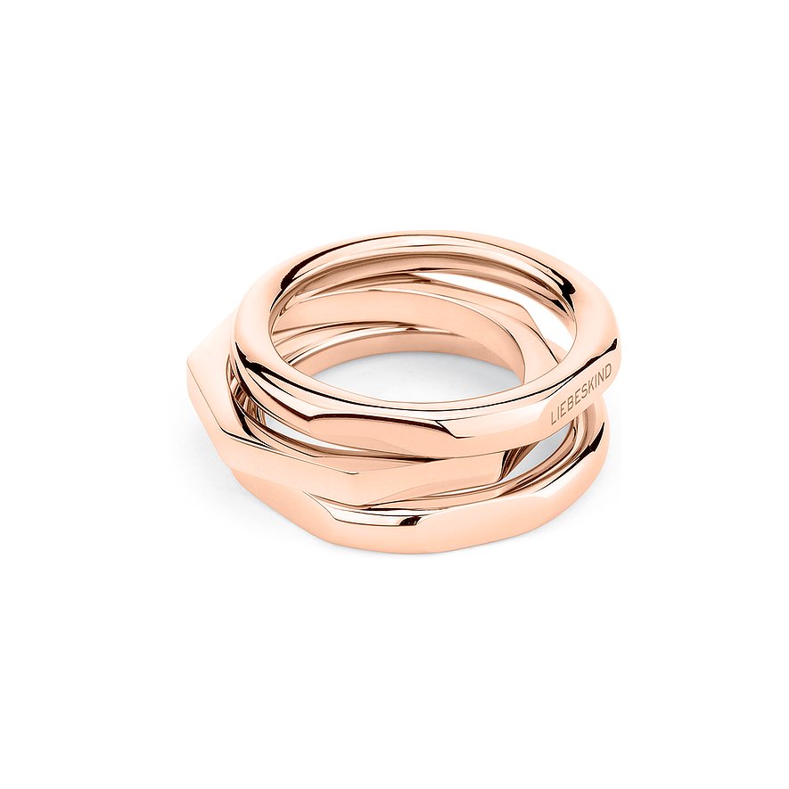Ein Set aus drei ineinander verschlungenen Liebeskind Ringen aus roségoldfarbenem Edelstahl auf weißem Hintergrund.