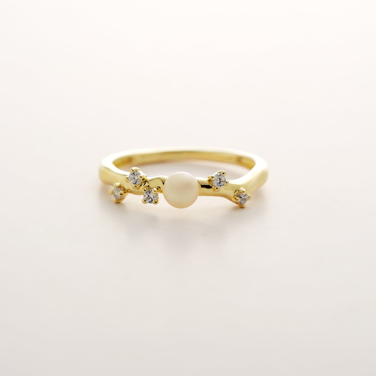 YAMOKO Ring aus 585er Gelbgold mit Perle, umgeben von kleinen, klaren Schmucksteinen, in Nahaufnahme.