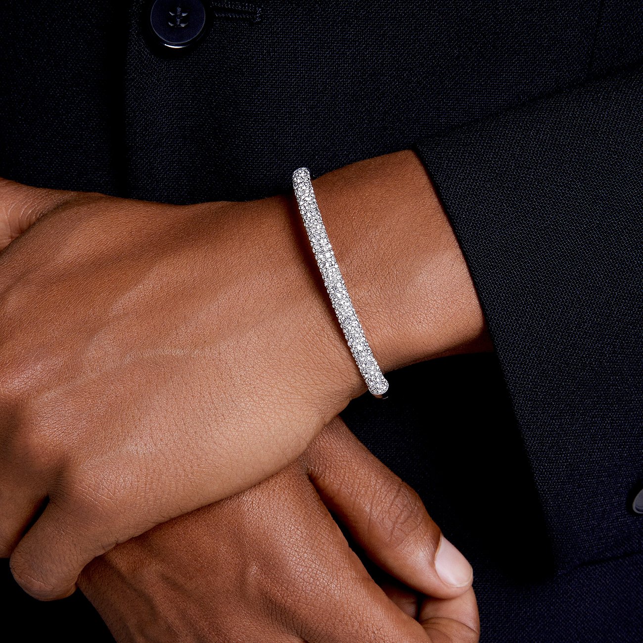 Een Swarovski metalen armband met kleine, rondom geplaatste Swarovski-kristallen om een pols.