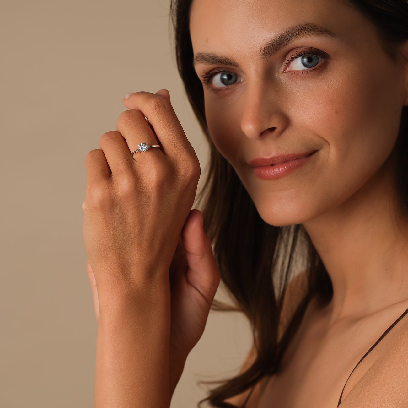 Nahaufnahme eines CHRIST 585er Weißgold Rings mit funkelndem Diamant, liebevoll getragen von einer Frau.