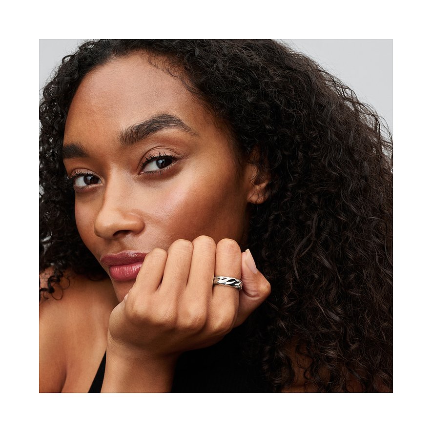 Eine Frau trägt einen silbernen Pandora Ring aus 925er Silber mit wellenförmigem Design am Ringfinger.