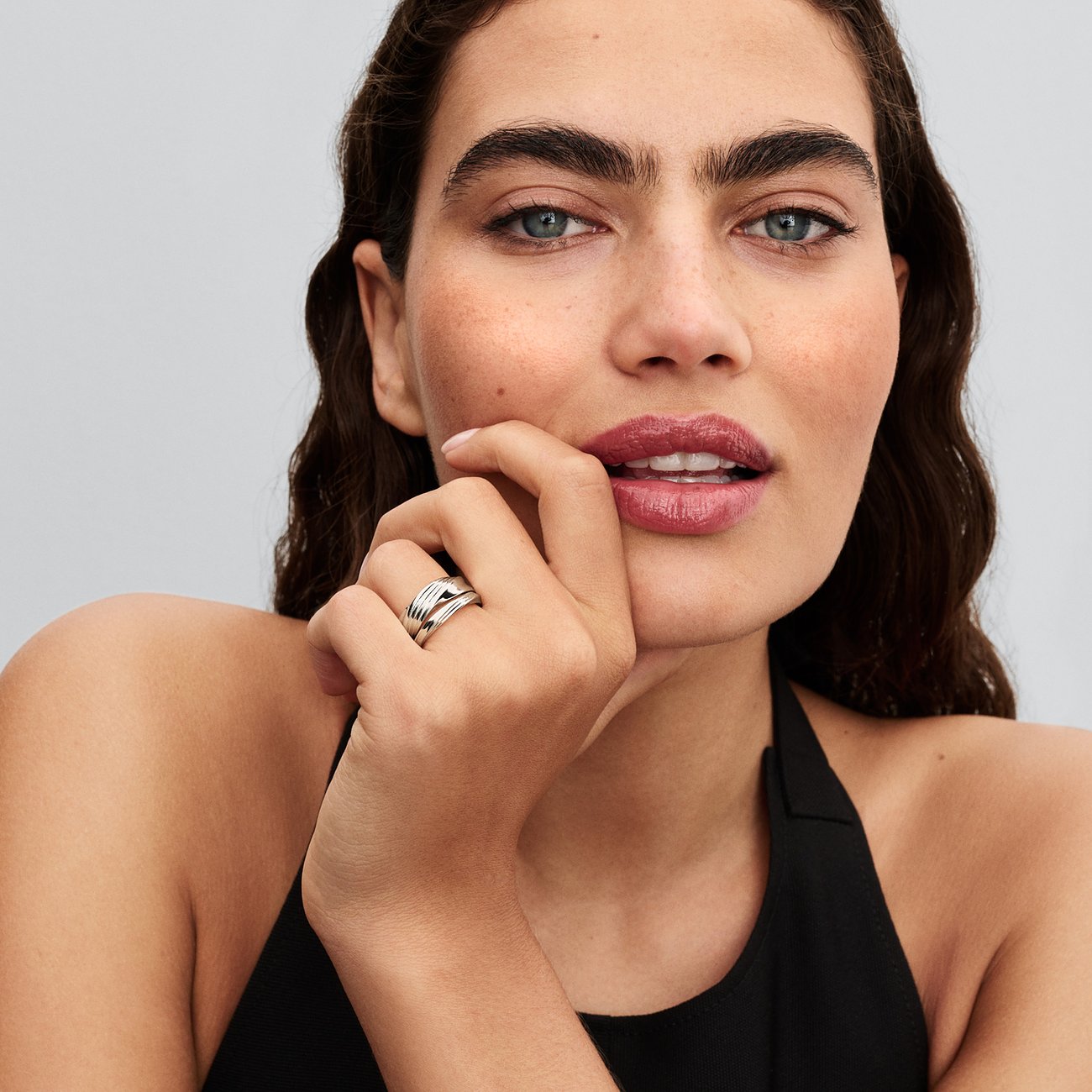 Ein Pandora Modering aus 925er Silber mit mehreren geschwungenen Bändern wird am Finger eines Models getragen.
