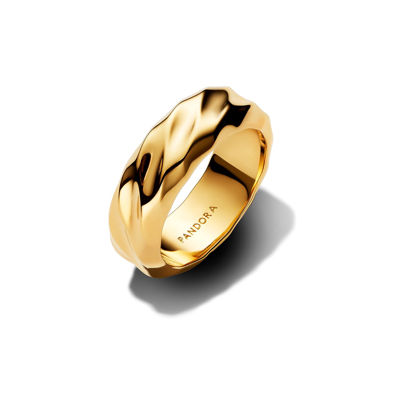 Pandora Ring aus goldenem Metall mit unregelmäßig geformter Oberfläche, leicht schräg und von oben rechts betrachtet.