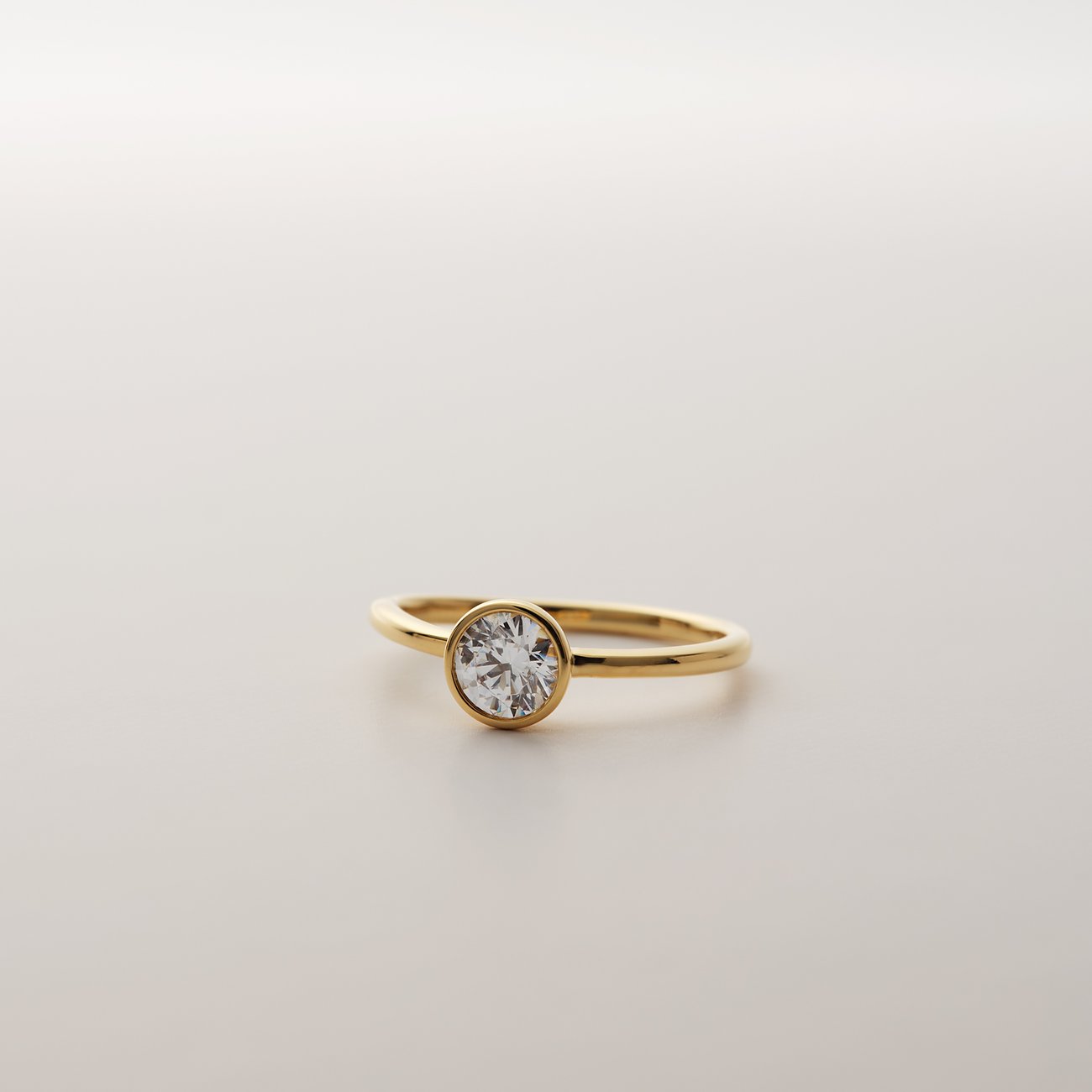 CHRIST ring van 585 geelgoud met een ronde diamant in een eenvoudige zetting, van voren gefotografeerd.