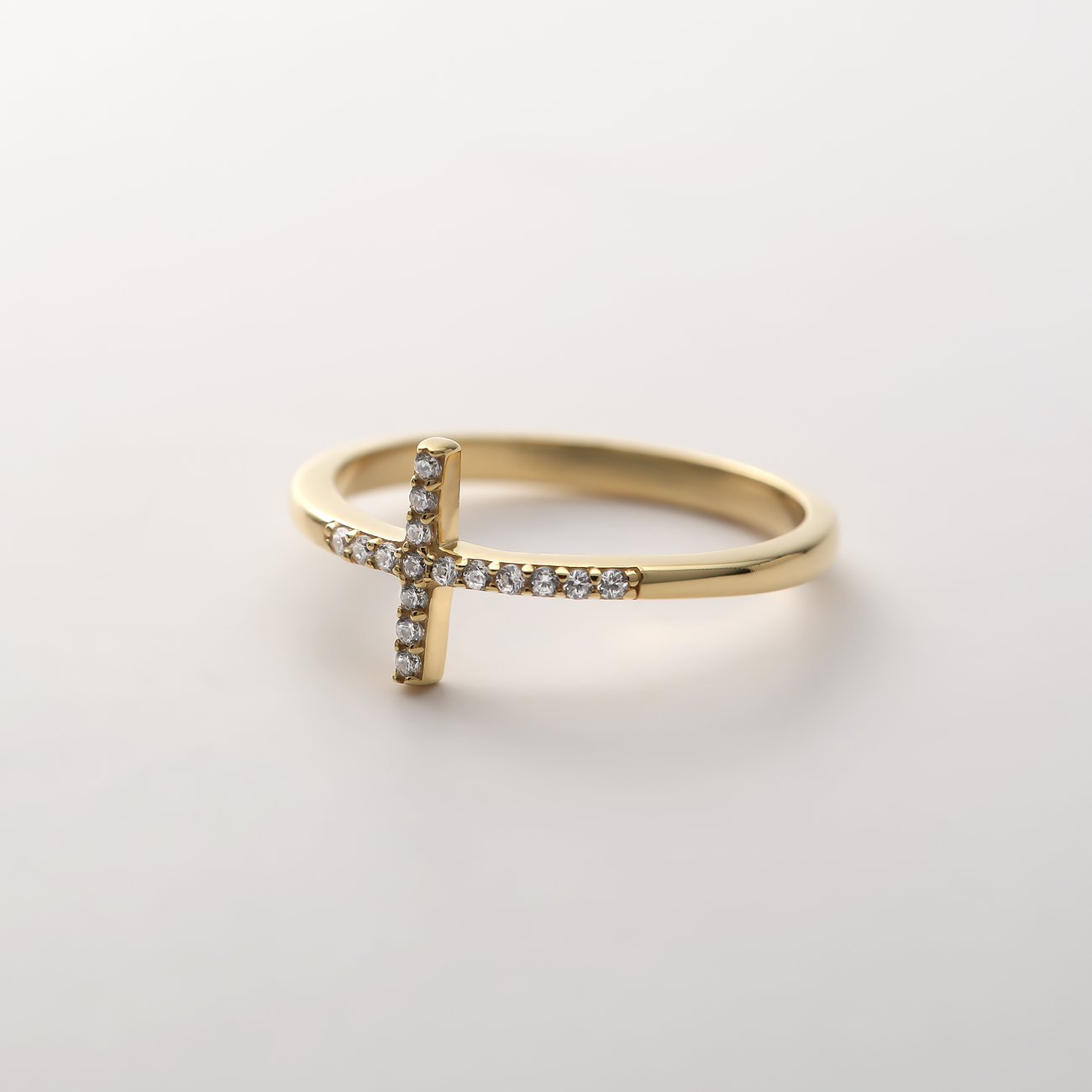 Ein CHRIST Ring aus recyceltem Silber mit vergoldetem Kreuz, besetzt mit funkelnden Zirkonia-Steinen.