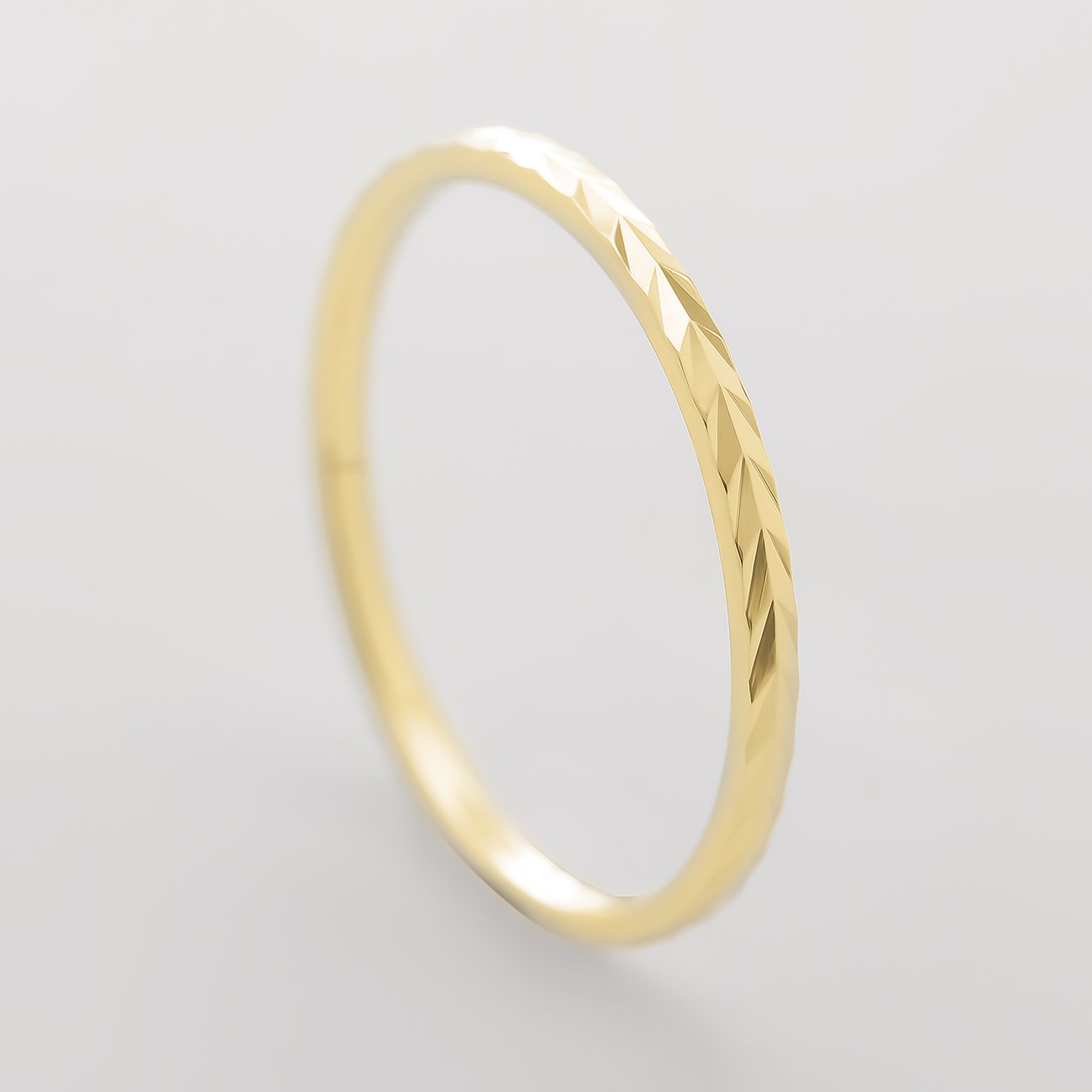 CHRIST ring i 375 gult guld, set fra oven, med facetslebet detalje på forsiden.