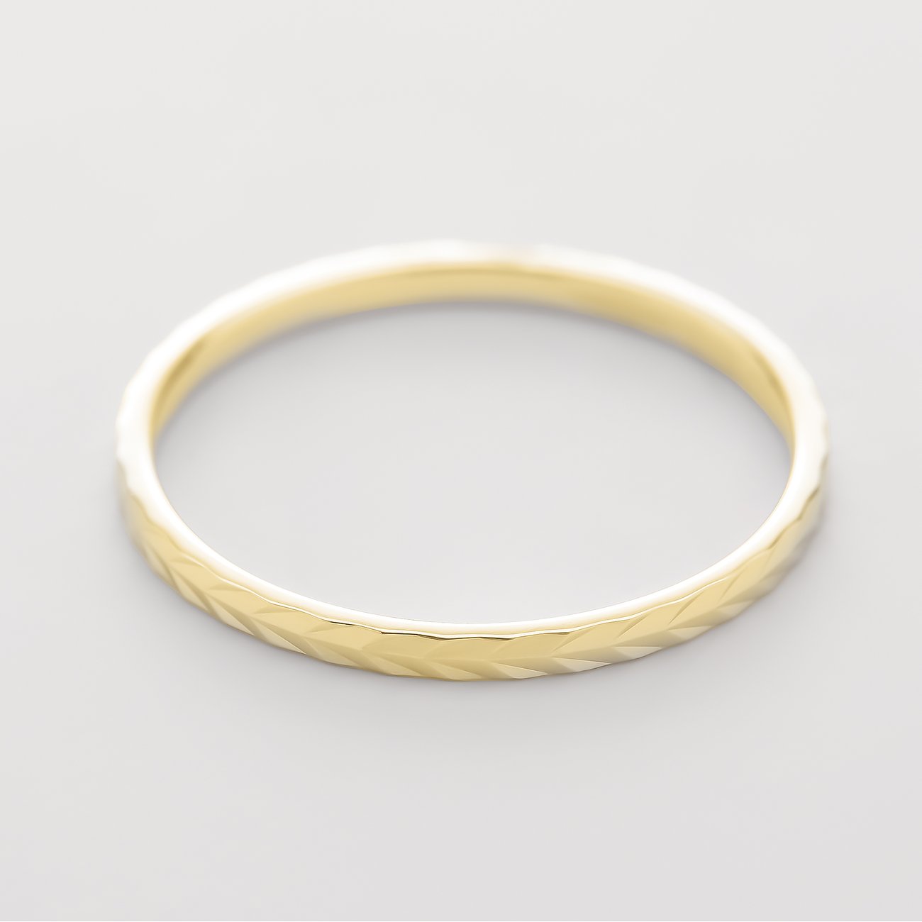 CHRIST ring af 375 gult guld, topvisning, med facetteret, skinnende overflade i chevronform.