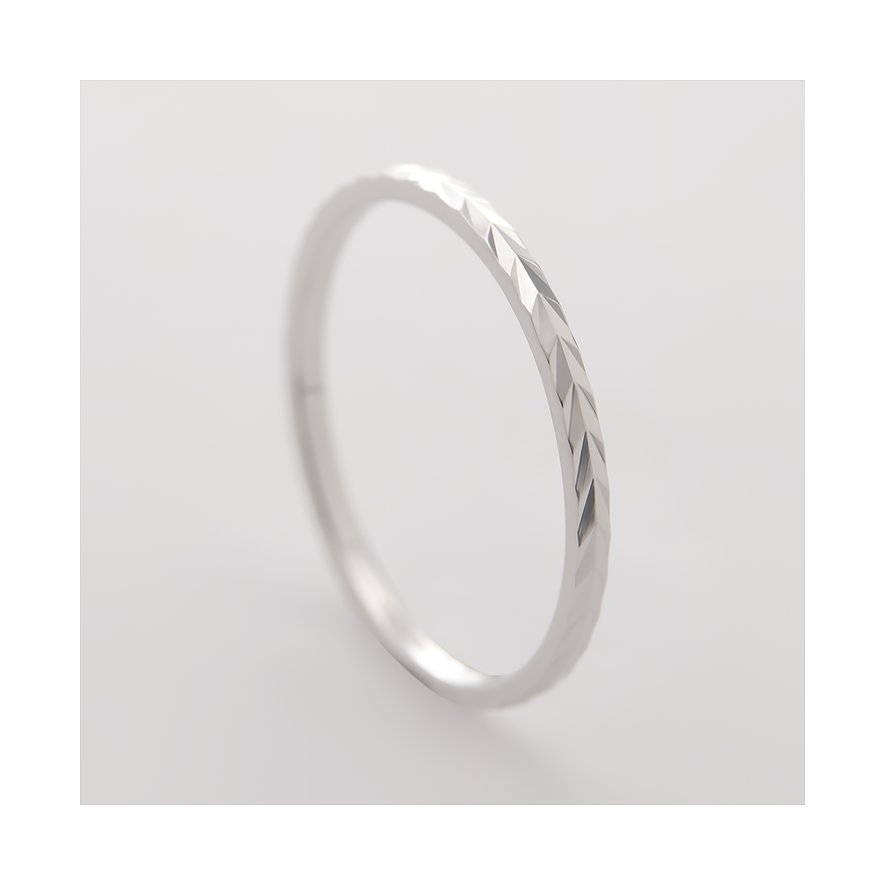 CHRIST-ring i 375 vitguld med filigran fasetterad yta, fotograferad lätt snett uppifrån.