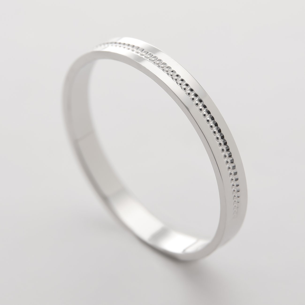 CHRIST Ring aus 375er Weißgold mit feinen, punktierten und schraffierten Details, schräg von oben aufgenommen.