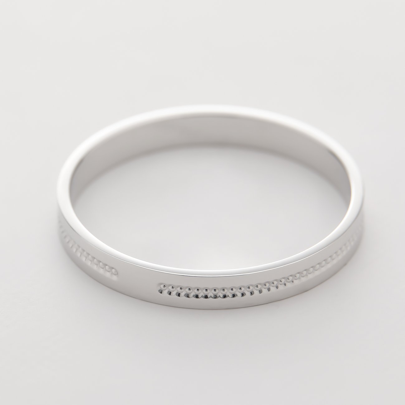 CHRIST 375er Weißgold-Ring. Ein schlichter, polierter Ring mit einem Muster aus kleinen Punkten entlang der Kante.