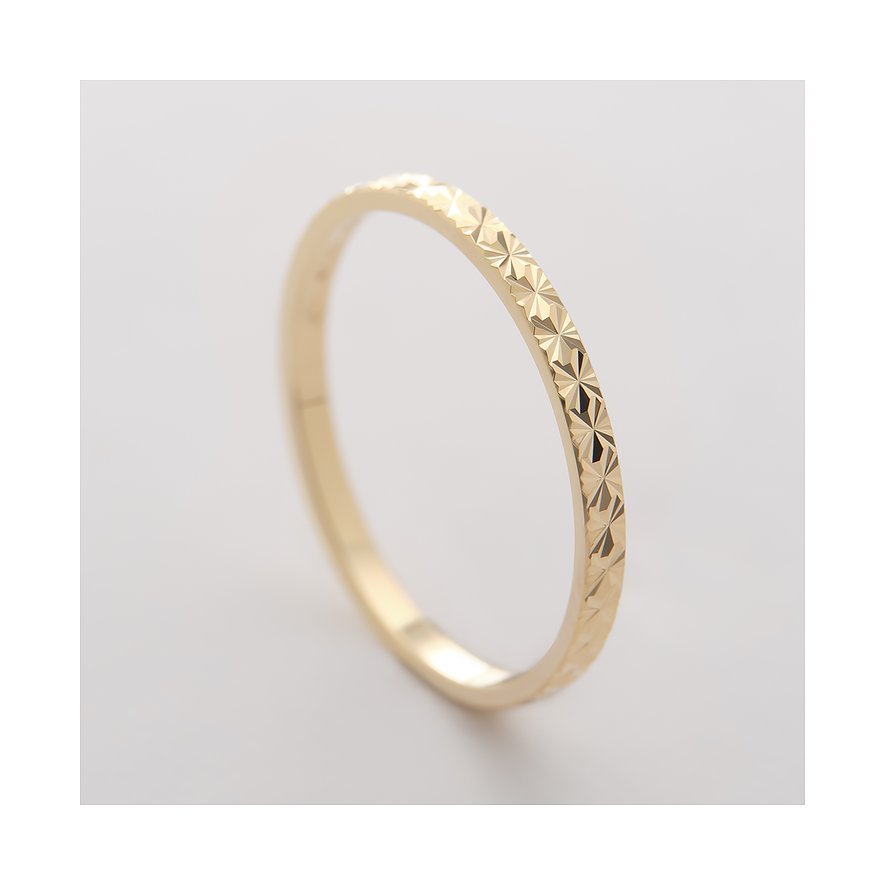CHRIST Ring aus 375er Gelbgold mit facettiertem Muster, schräg von oben aufgenommen.