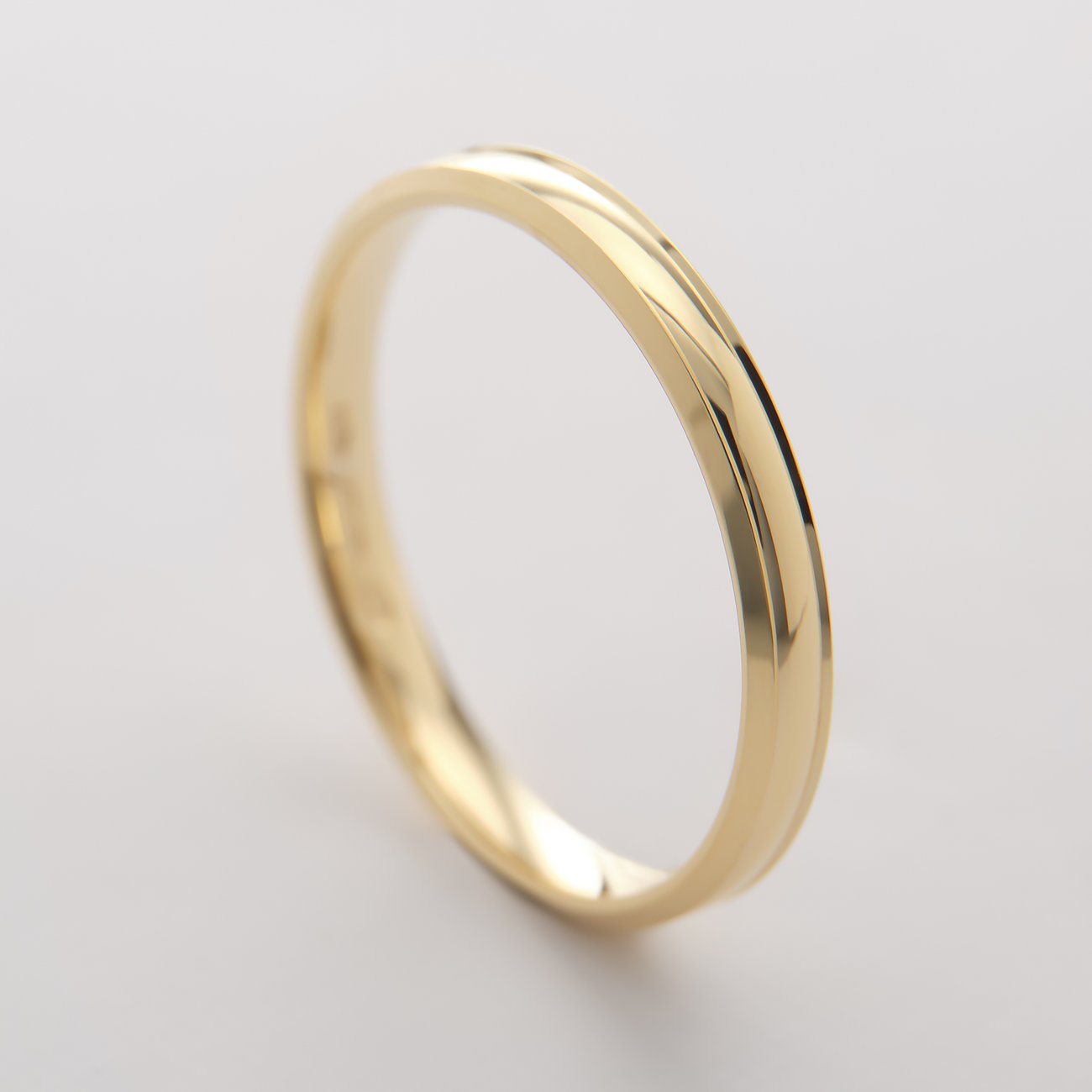 Close-up van een CHRIST ring van geelgoud, 375 legering, met een subtiele gebogen groef aan de bovenzijde.