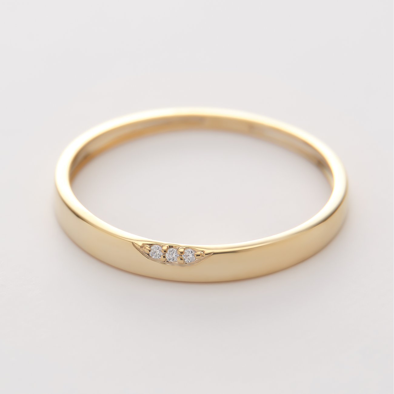 CHRIST 375 gult guldring med tre zirkoniastenar, snett infattade i en bredare ringskena.