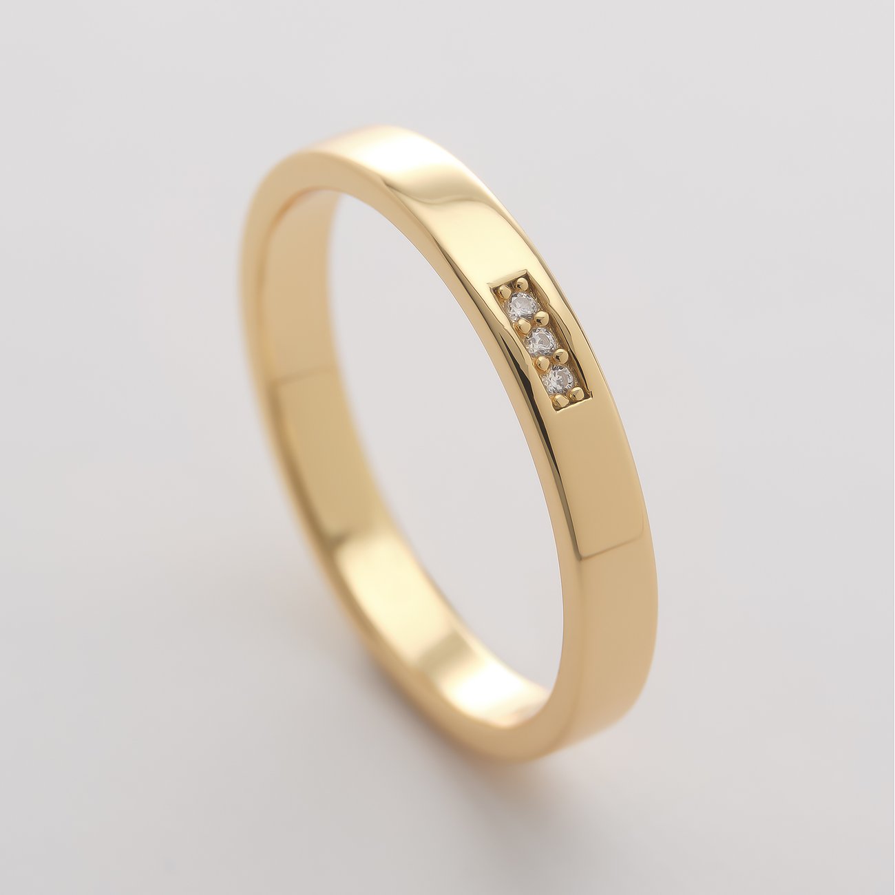 CHRIST Ring aus roséfarbenem recyceltem Silber mit drei funkelnden Zirkonia-Steinen, schräg von oben betrachtet