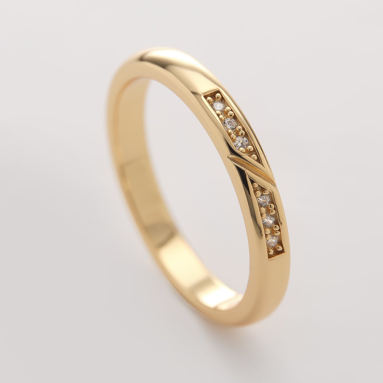 CHRIST ring i guldfärgat återvunnet silver, prydd med flera gnistrande zirkonia-färgade stenar i geometriska spår.