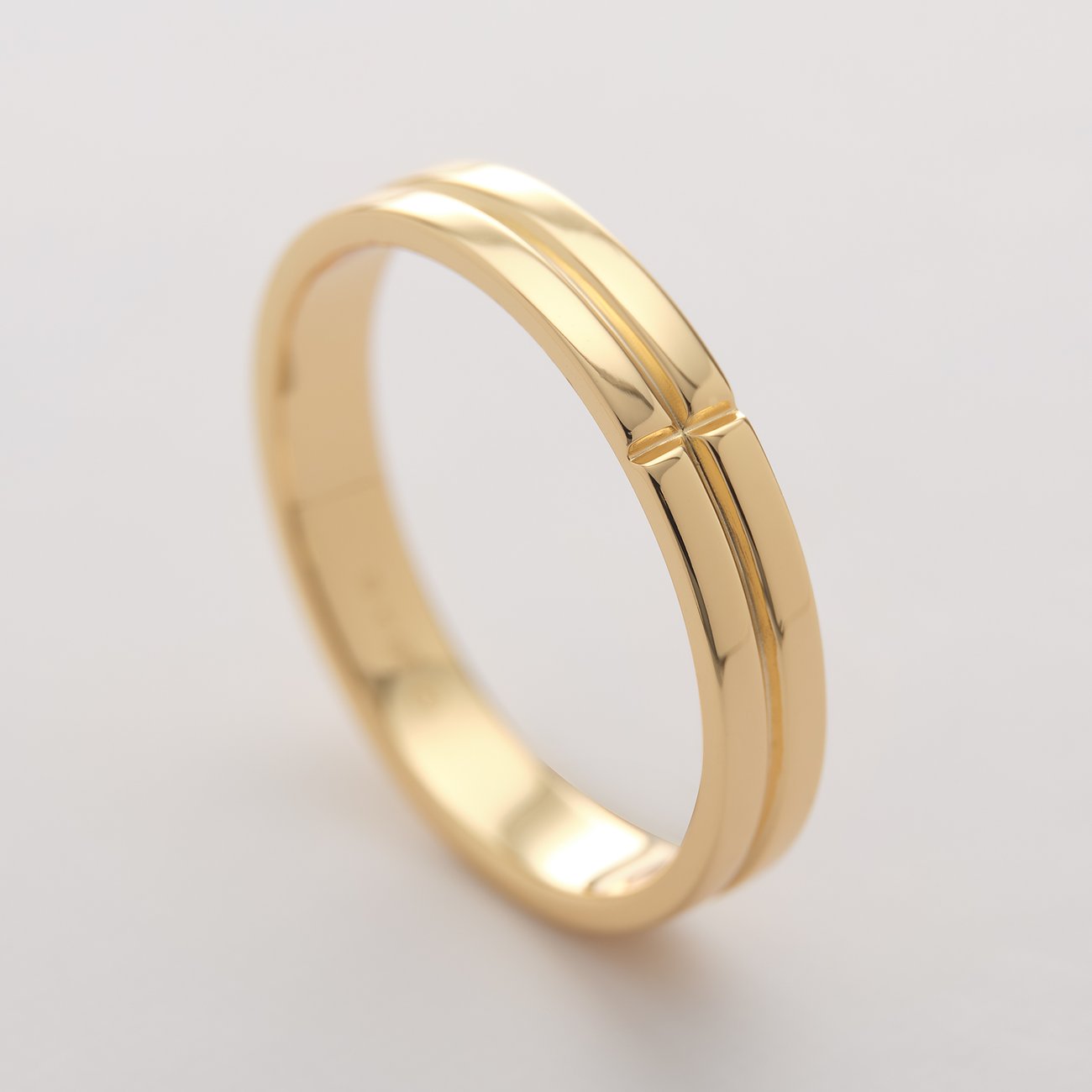 Nahaufnahme eines minimalistischen CHRIST Rings aus glänzendem Gold in der Draufsicht.