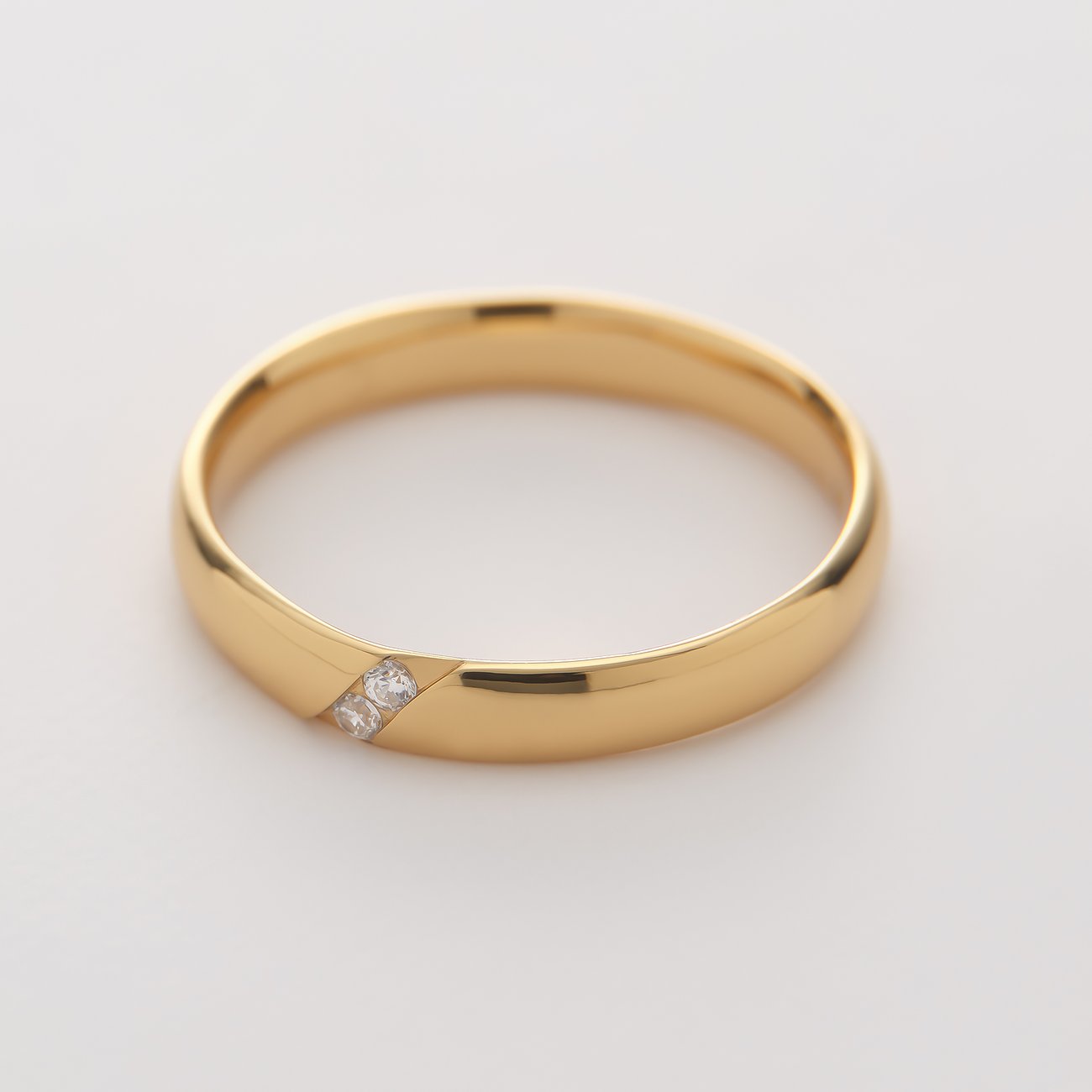 CHRIST ring af guldfarvet genanvendt sølv med to diagonalt indsatte zirkonia-sten.