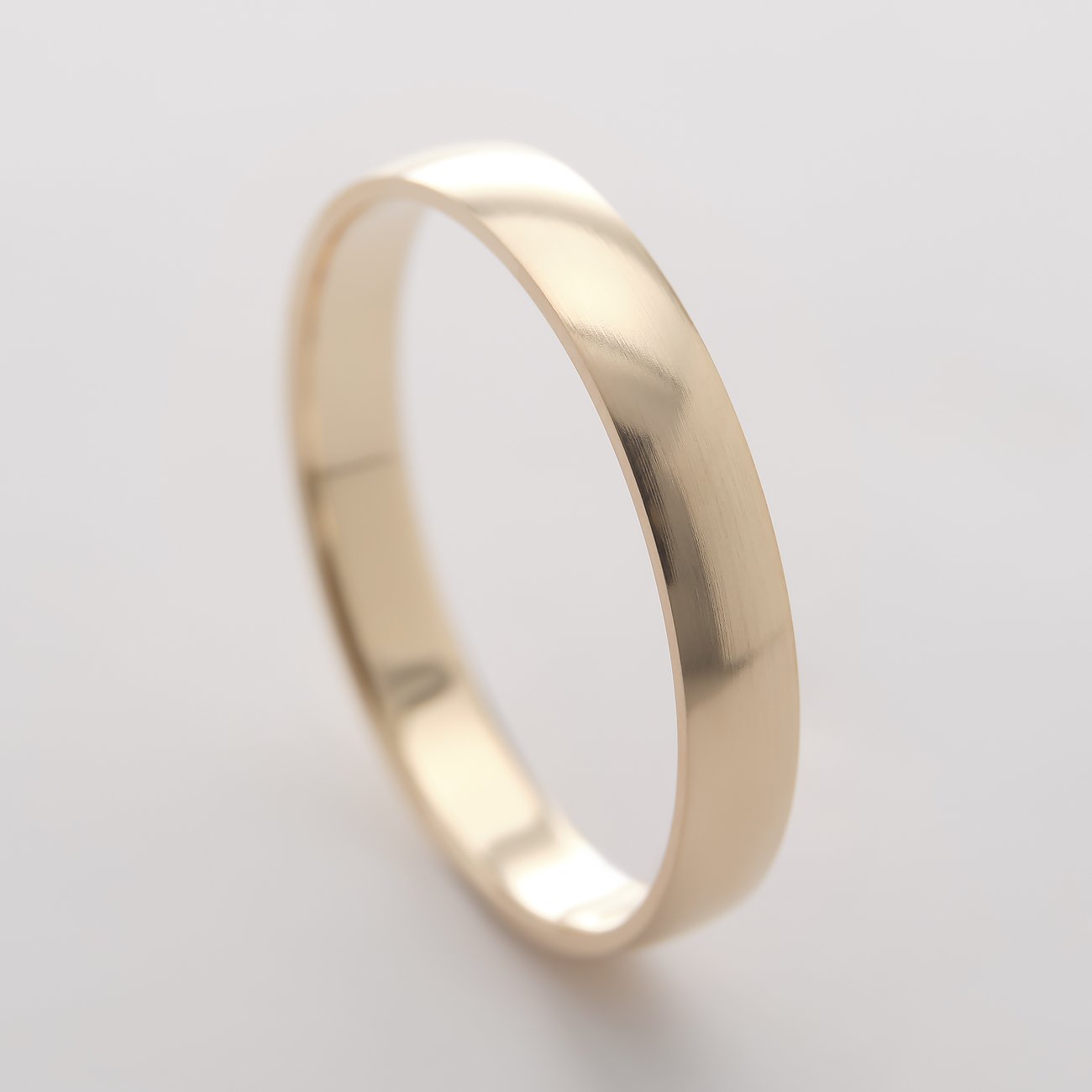 Une bague CHRIST brillante en or jaune 375, photographiée d'en haut. Sa surface lisse reflète légèrement.