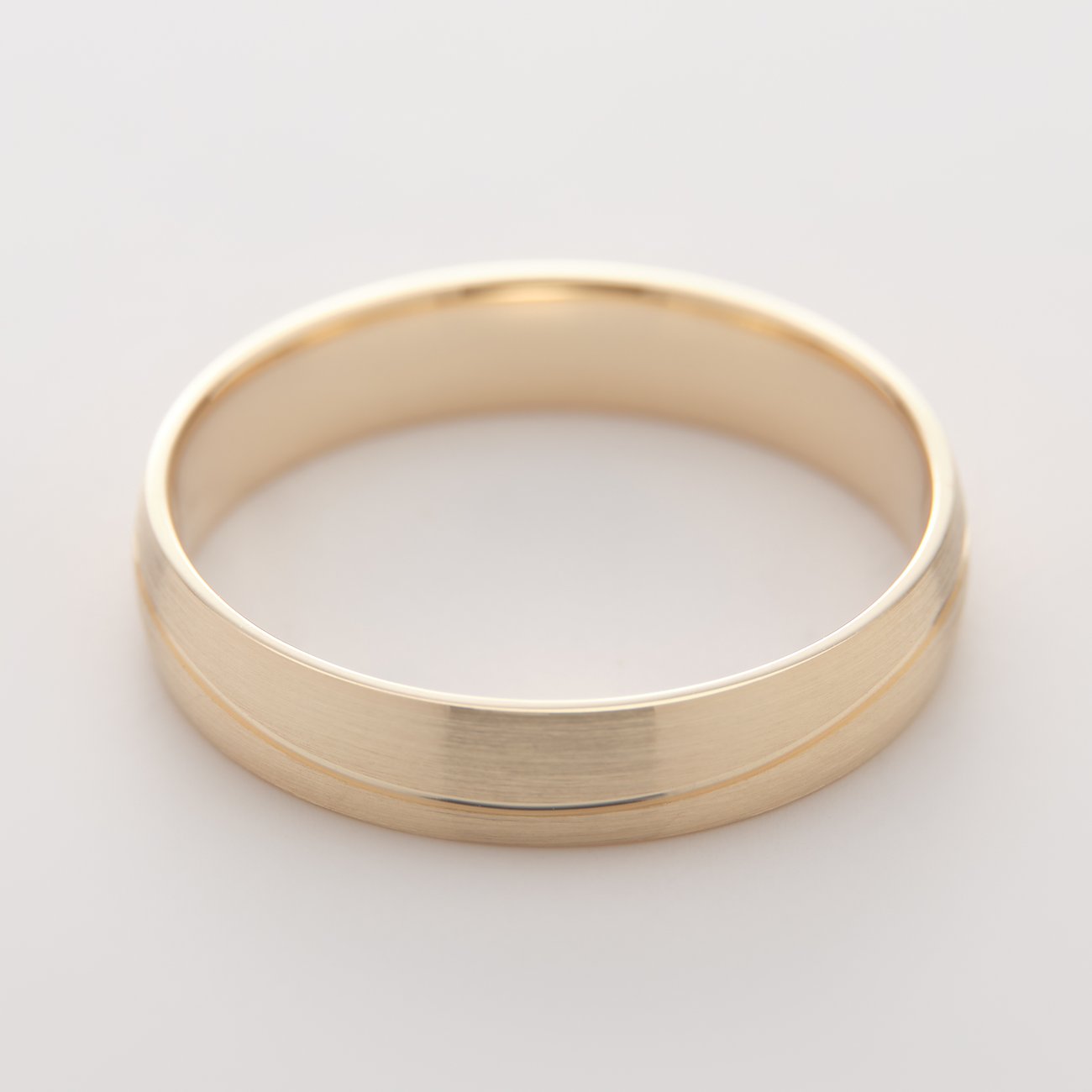 Ein glänzender goldener CHRIST Ring aus Gelbgold, mit einer gebürsteten Rille, die den Ring horizontal teilt.