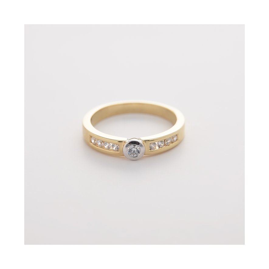 CHRIST-ring i gult och vitt guld med en rundinfattad diamant och flera kanalinfattade diamanter.