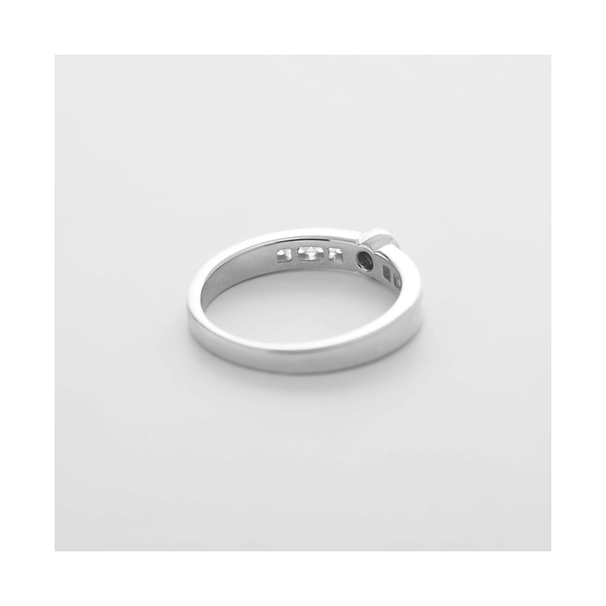 CHRIST Ring aus 585 Weißgold mit drei funkelnden Diamanten, schräg von hinten fotografiert.