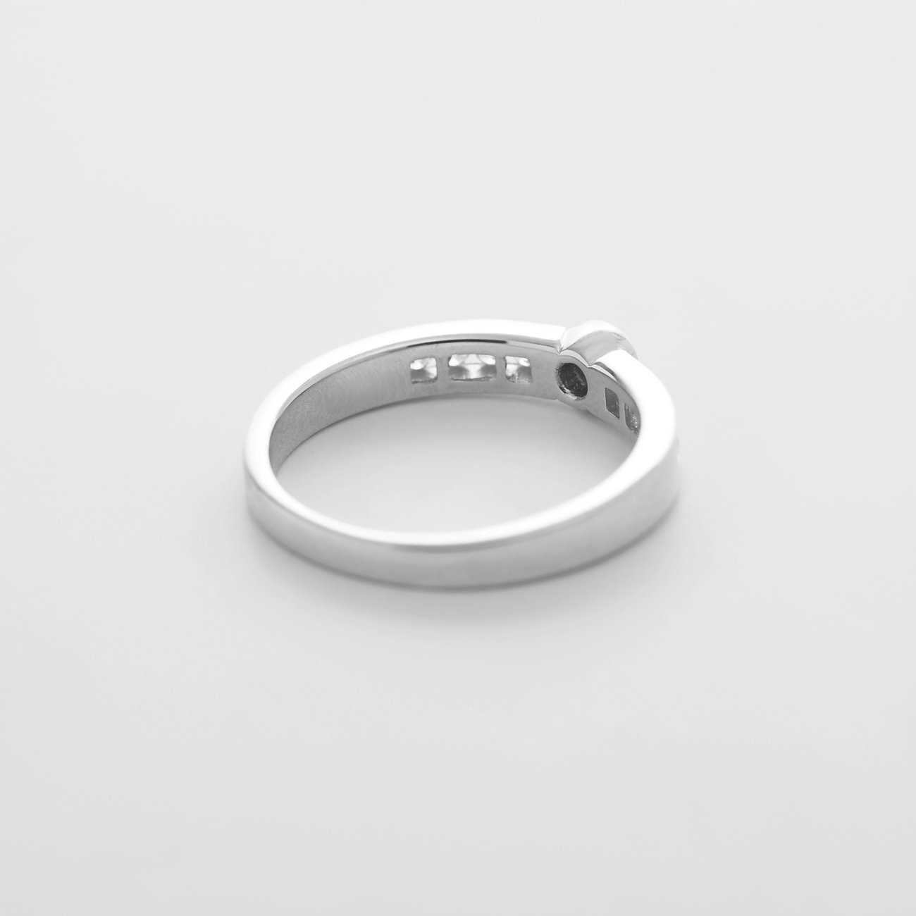 CHRIST Ring aus 585 Weißgold mit drei funkelnden Diamanten, schräg von hinten fotografiert.
