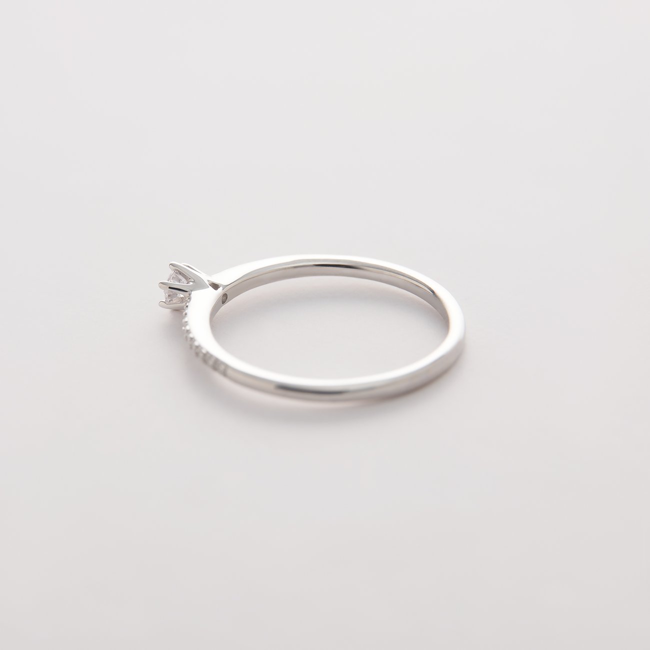 CHRIST ring van 585 witgoud met een centrale en kleine diamanten op de ringband, zijaanzicht.