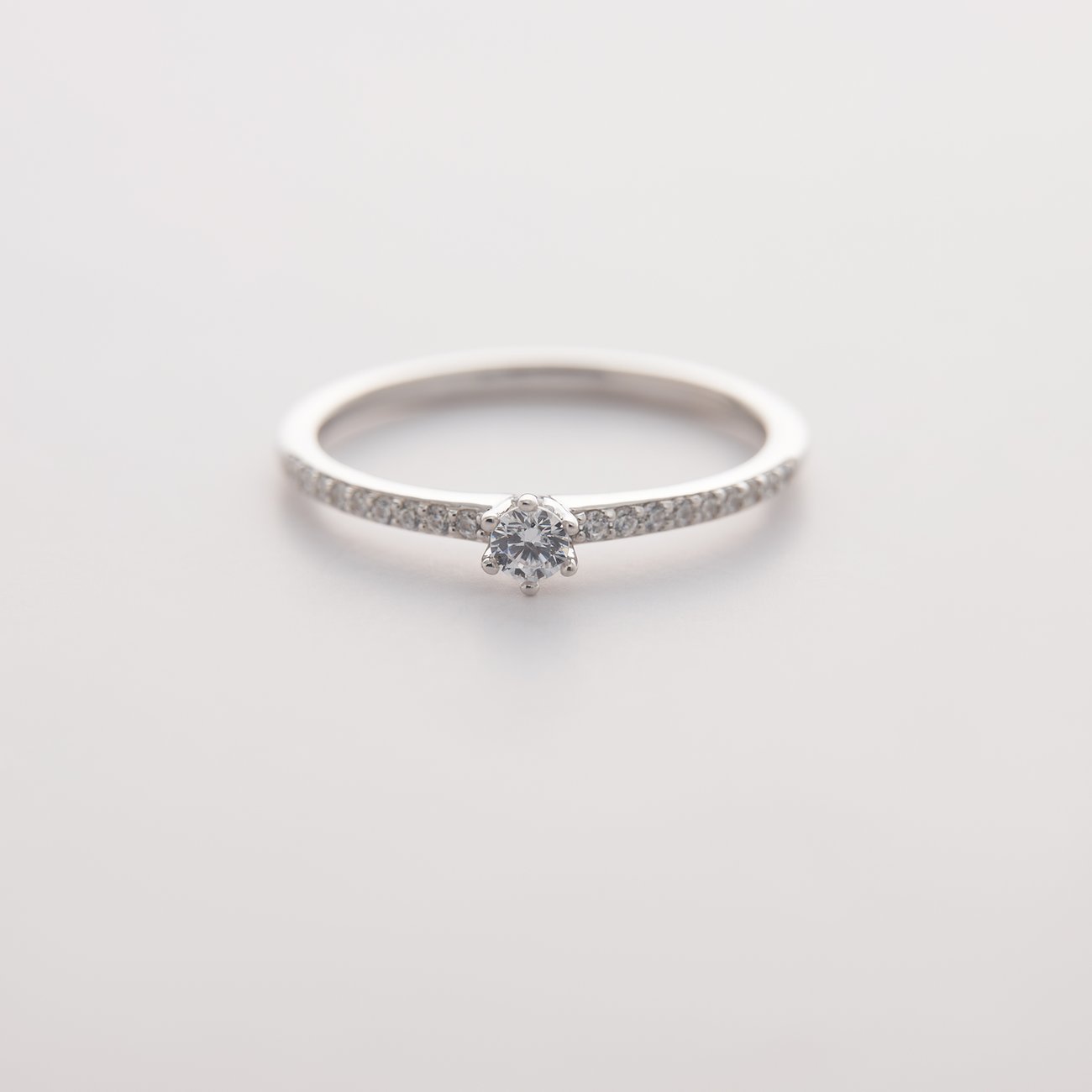 CHRIST 585 witgouden ring met een centrale diamant en kleine diamanten op de ringband.